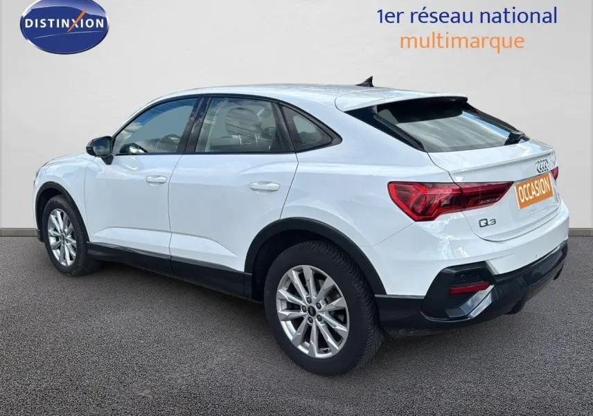 Audi Q3 Sportback blanc vu de trois quarts arrière côté gauche, avec jantes alliage et feux arrière LED.