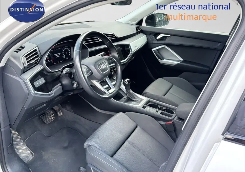 Intérieur noir de l'Audi Q3 Sportback blanc 2021, vue côté conducteur avec tableau de bord et console centrale visibles.
