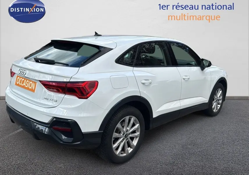 Audi Q3 Sportback blanc vue 3/4 arrière côté droit, avec feux arrière LED et jantes alliage 18 pouces.