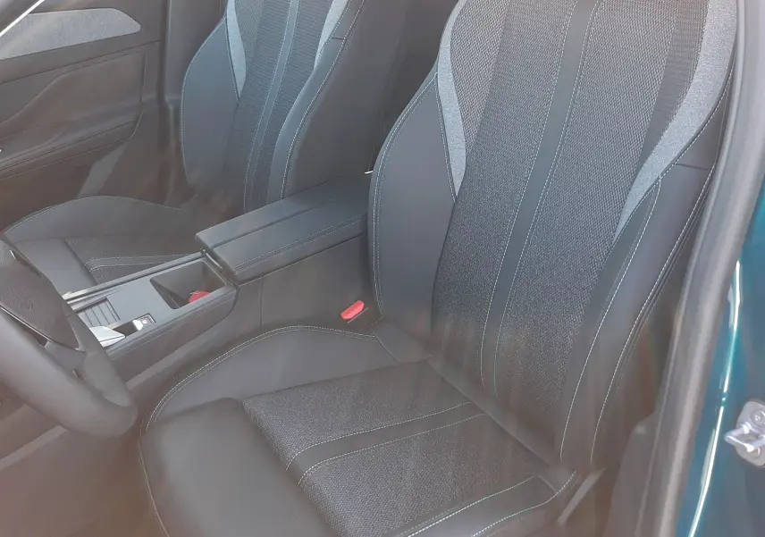 Vue intérieure côté arrière gauche de la Peugeot 308 2026 bleu obsession, montrant les sièges arrière en tissu avec surpiqûres contrastantes.
