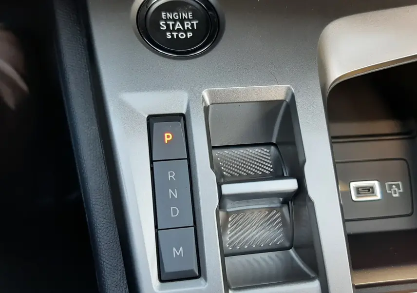 Gros plan sur les commandes multifonctions noires à gauche du volant en cuir d'une Peugeot 308 2026.