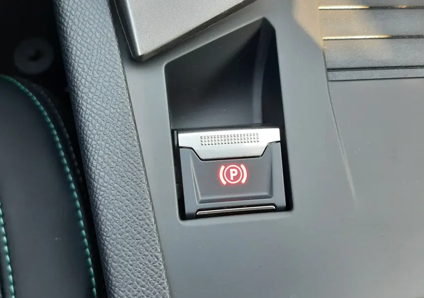 Gros plan sur le bouton Drive Mode noir intégré dans la console centrale grise du Peugeot 308 Bleu Obsession 2026.