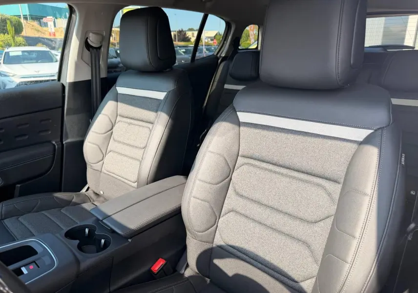 Vue intérieure rapprochée des sièges avant en tissu noir et cuir du Citroën C5 Aircross 2025, avec accoudoir central.