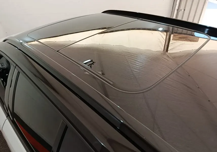 Toit ouvrant panoramique en verre du Volvo XC40 P8 gris clair vu de dessus côté gauche.
