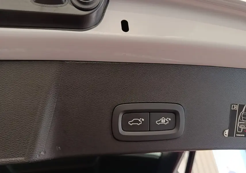 Gros plan sur les boutons d'ouverture et de verrouillage du coffre électrique du Volvo XC40 gris clair, vue intérieure du hayon.