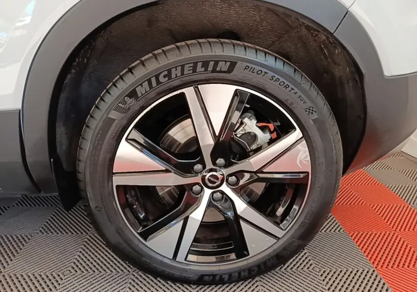 Gros plan sur la roue arrière droite du Volvo XC40 P8 gris clair, avec jante alliage bicolore et pneu Michelin Pilot Sport 4 SUV.