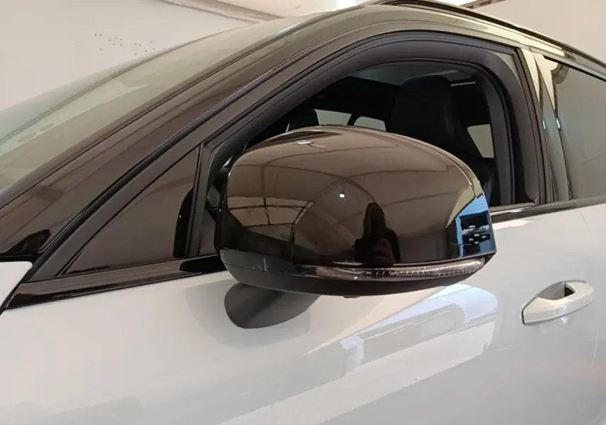 Rétroviseur noir brillant côté gauche du Volvo XC40 P8 gris clair, vue rapprochée sur la porte avant.