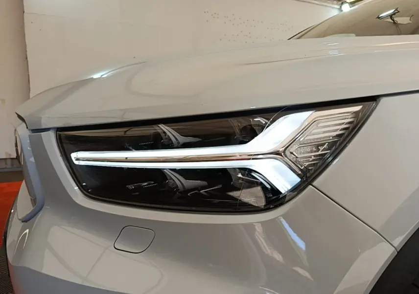 Gros plan sur le phare avant droit gris clair du Volvo XC40 P8 R-Design avec signature lumineuse LED distinctive.