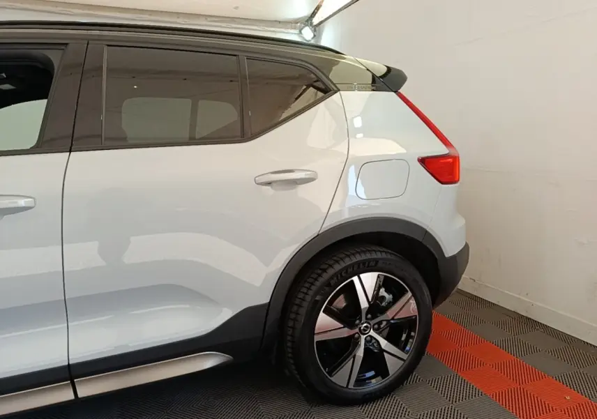 Vue latérale droite du Volvo XC40 P8 gris clair, mettant en valeur la jante alliage et le toit noir contrastant.