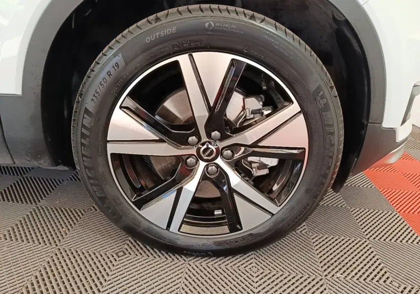 Gros plan sur la roue avant droite du Volvo XC40 P8 gris clair, jante alliage bicolore et pneu Michelin visible.