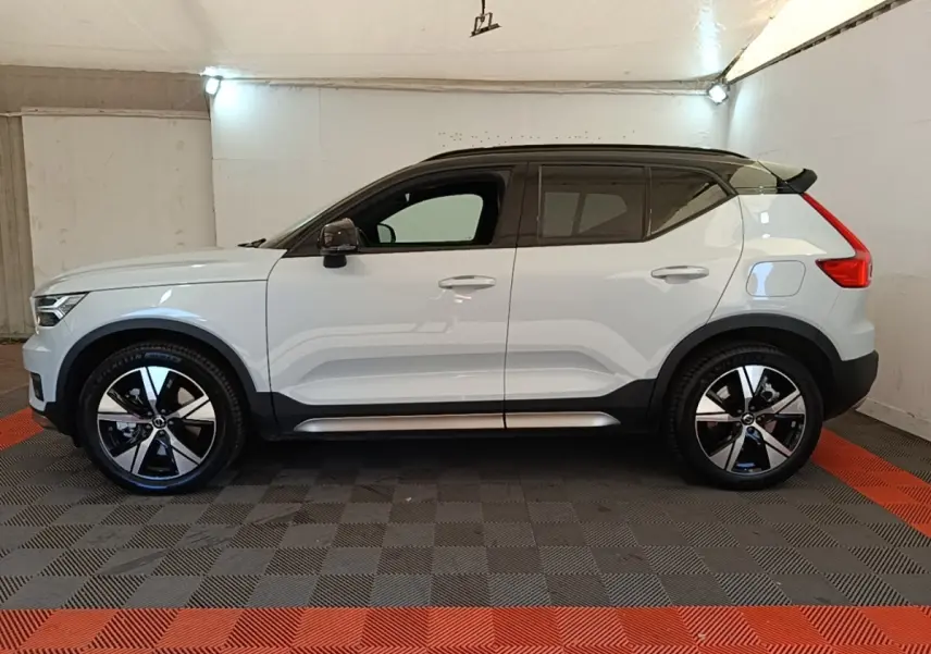 Vue latérale gauche d'un Volvo XC40 P8 gris clair avec toit noir et jantes alliage bicolores en intérieur.