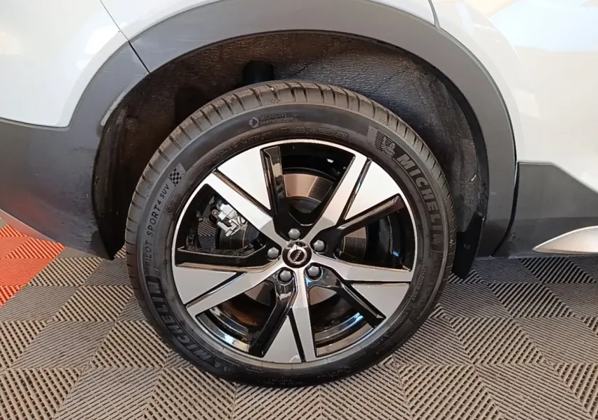 Gros plan sur la roue arrière droite du Volvo XC40 gris clair avec jante alliage bicolore et pneu Michelin.