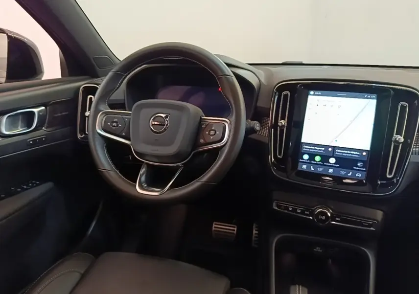 Vue intérieure du tableau de bord et volant noir du Volvo XC40 P8 électrique avec écran tactile central allumé.