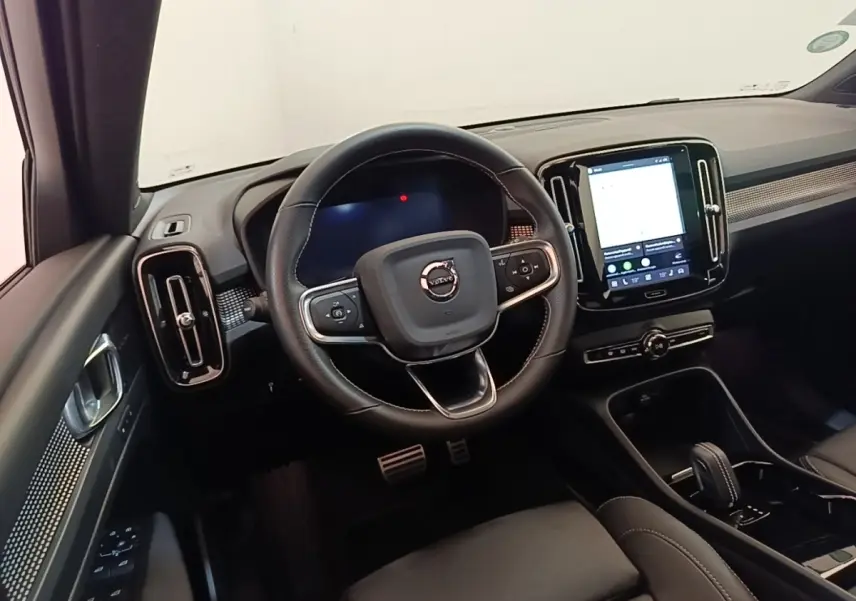 Intérieur noir du Volvo XC40 P8 408 R-Design 2021, vue centrée sur le volant et l’écran tactile vertical du tableau de bord.
