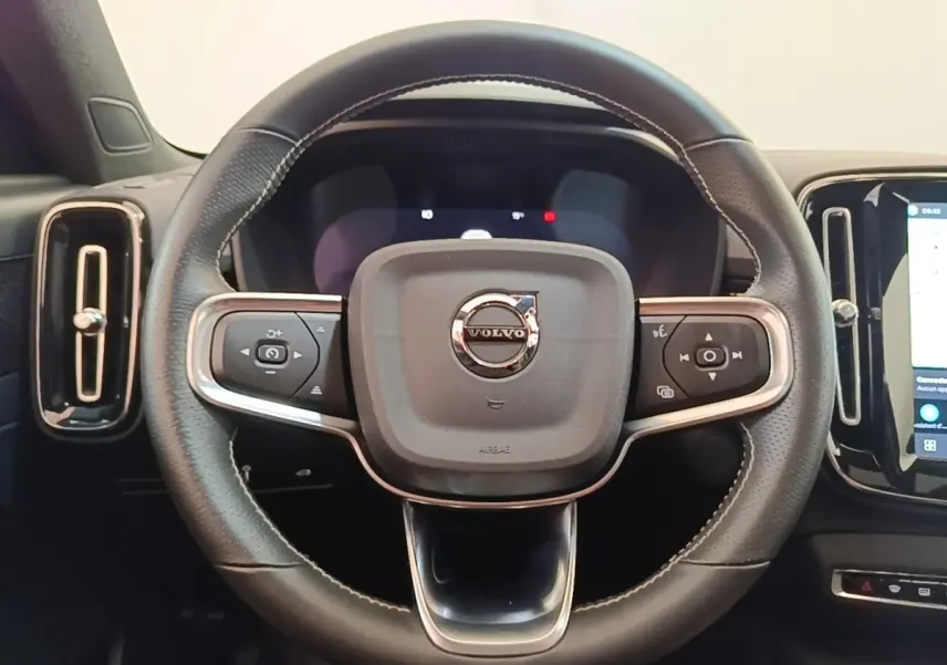 Volant cuir noir avec surpiqûres blanches de Volvo XC40 P8 R-Design, vue frontale centrée sur le logo.