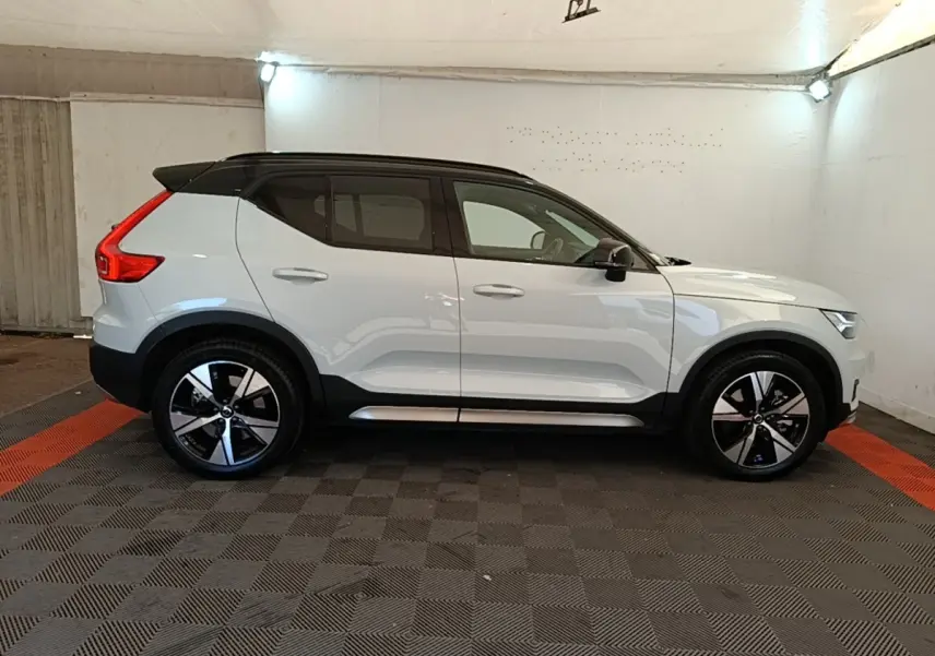 Vue de profil côté gauche d'un Volvo XC40 P8 R-Design gris clair avec toit noir et jantes alliage bicolores.
