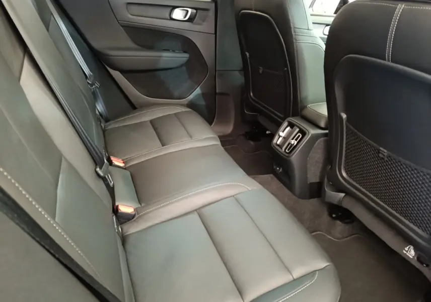 Vue intérieure arrière du Volvo XC40 P8 gris clair, montrant la banquette 3 places en cuir avec aérateurs centraux.
