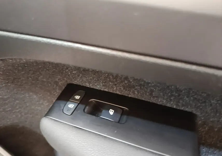 Gros plan sur les commandes de verrouillage des portes dans l'habitacle du Volvo XC40 gris clair.