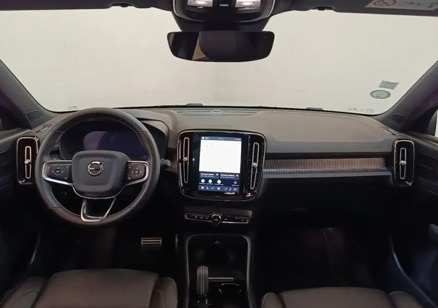 Vue intérieure frontale du tableau de bord noir du Volvo XC40 P8 408 R-Design avec écran tactile central vertical.