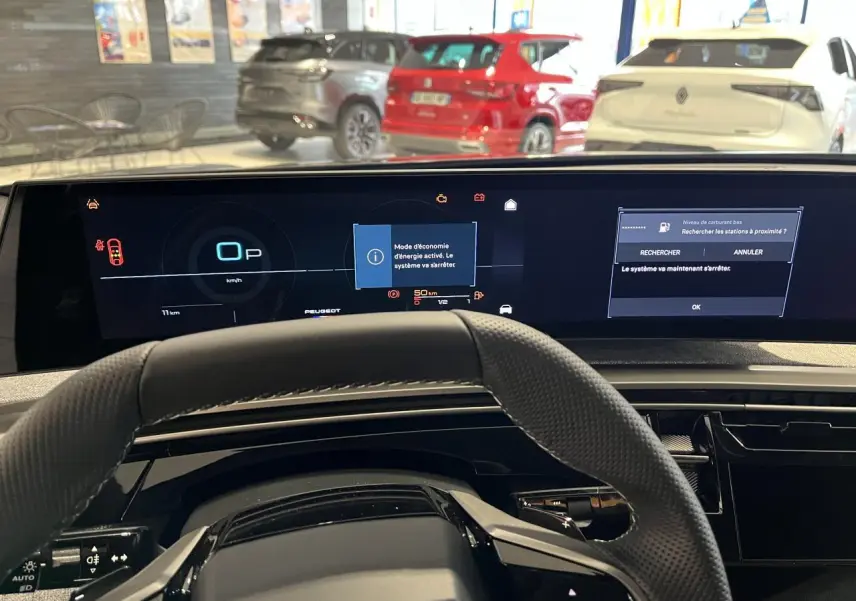 Vue intérieure centrée sur le tableau de bord numérique et volant cuir perforé du Peugeot 3008 gris titanium 2025.