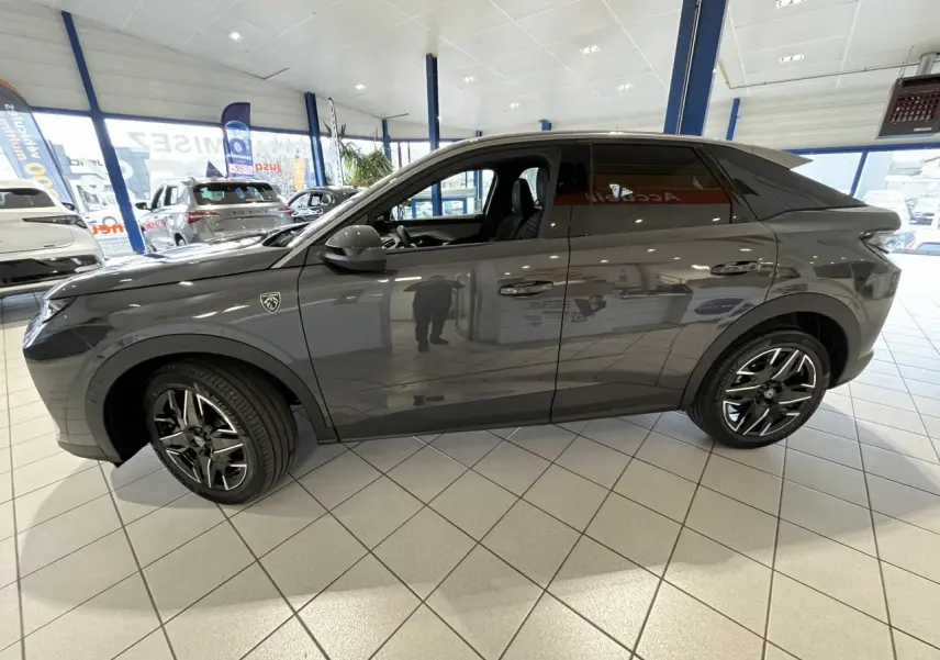 Vue de profil côté gauche d'un Peugeot 3008 gris titanium avec jantes alliage noires et toit Black Diamond.
