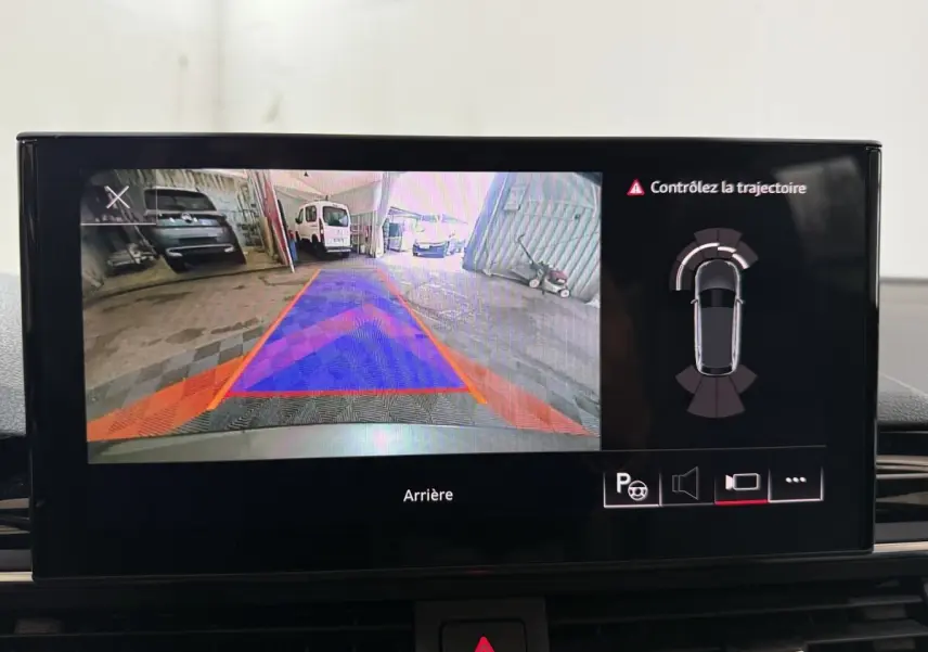 Écran intérieur affichant la caméra de recul et l'aide au stationnement de l'Audi A4 gris foncé, vue arrière.