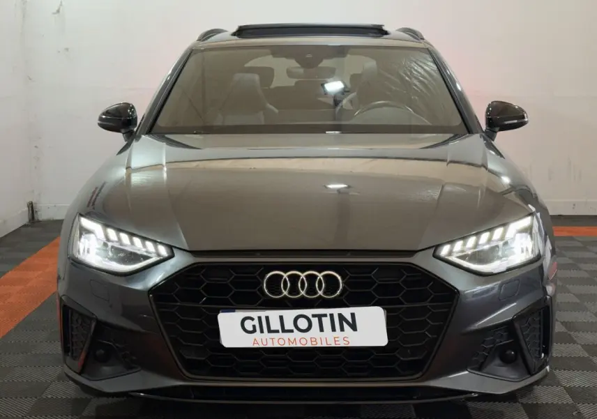 Audi A4 35 TFSI S Edition gris foncé vue de face avec phares LED allumés et calandre noire hexagonale.