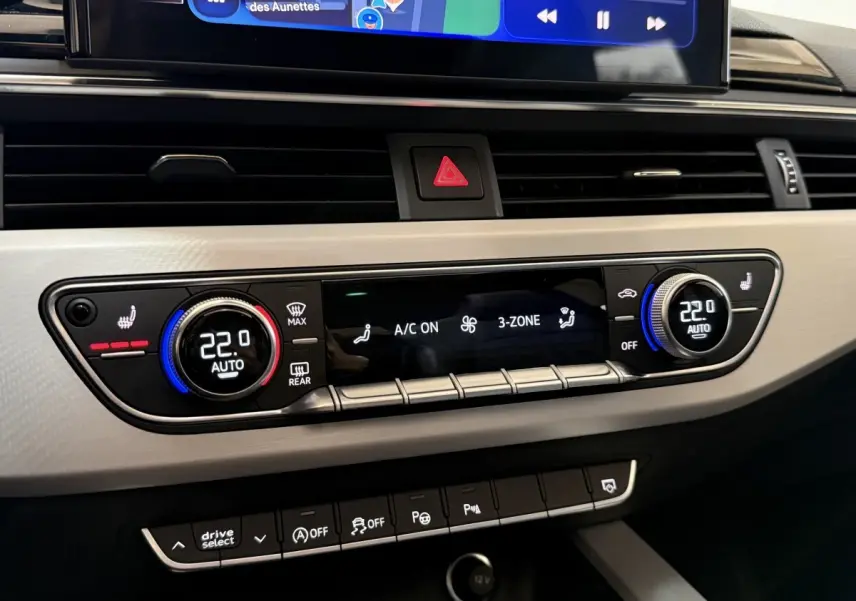 Détail du tableau de bord de l’Audi A4 gris foncé 2022, montrant la climatisation automatique 3 zones et les commandes tactile.