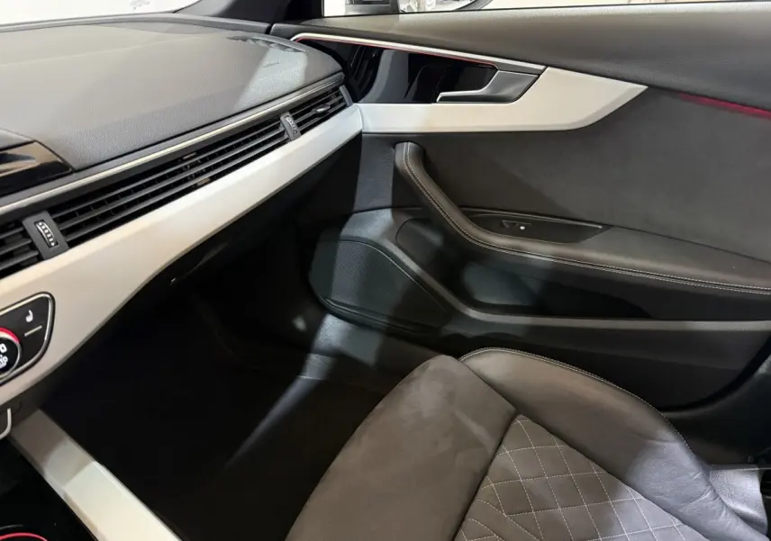 Vue intérieure côté passager de l'Audi A4 35 TFSI 2022, avec sellerie cuir gris et tableau de bord clair.