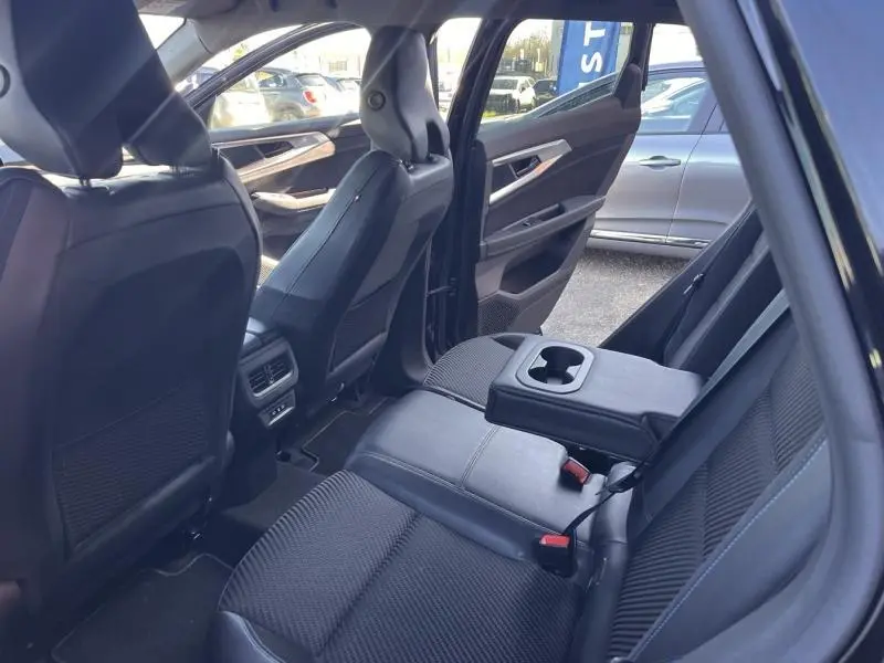 Vue intérieure arrière côté gauche du Renault Austral noir étoilé, montrant les sièges en tissu carbone/Alcantara et l'accoudoir central avec porte-gobelets.