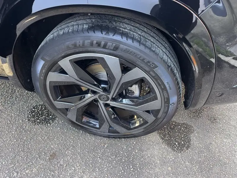 Gros plan sur la roue avant droite noire étoilé du Renault Austral 1.2 E-Tech avec jante alu au design moderne.