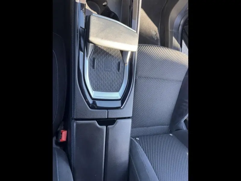 Vue plongeante sur l'accoudoir central noir étoilé et siège avant tissu carbone/Alcantara du Renault Austral 2023.