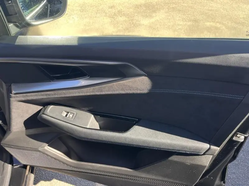 Vue côté gauche de la porte intérieure noire étoilé du Renault Austral 2023 avec commandes de fenêtre et finition alcantara.