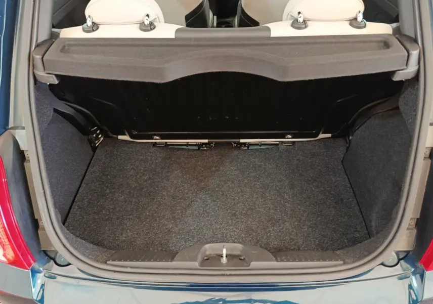 Coffre ouvert vu de dessus d'une FIAT 500 Dolcevita bleu, montrant la banquette arrière beige et le tapis de coffre.