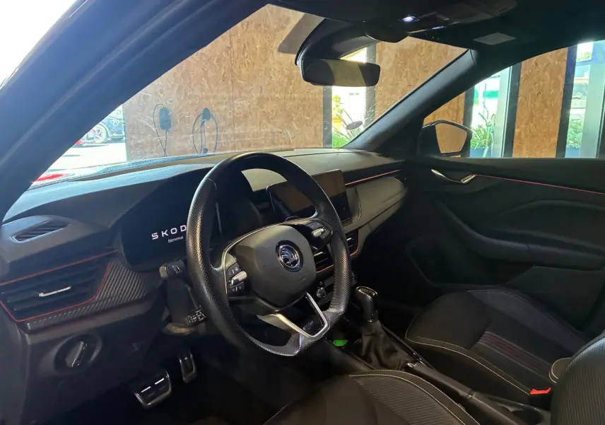 Intérieur noir du Skoda Kamiq 1.5 TSI 150 DSG7 2024, vue côté conducteur avec tableau de bord et volant sport.