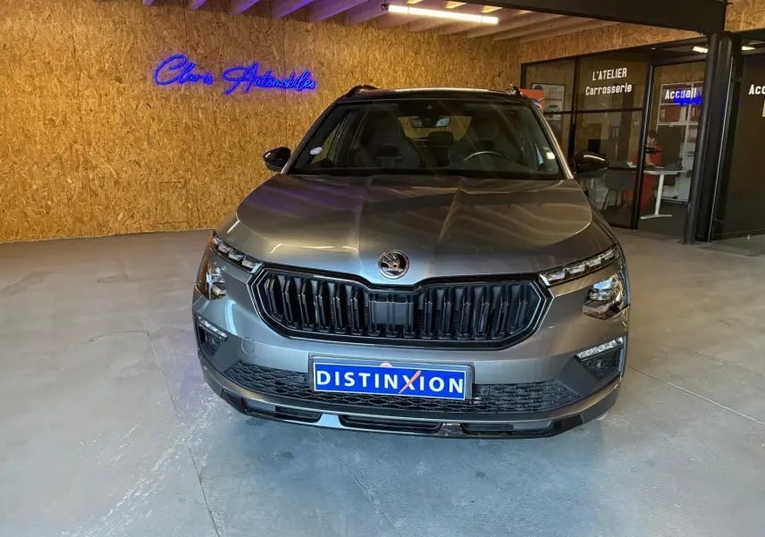 Vue frontale d'un Skoda Kamiq 1.5 TSI 150 DSG7 Monte-Carlo gris foncé, avec calandre noire et éclairage LED.
