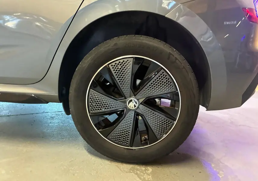 Gros plan sur la roue arrière droite du Skoda Kamiq gris foncé 2024 avec jante au design moderne bicolore.