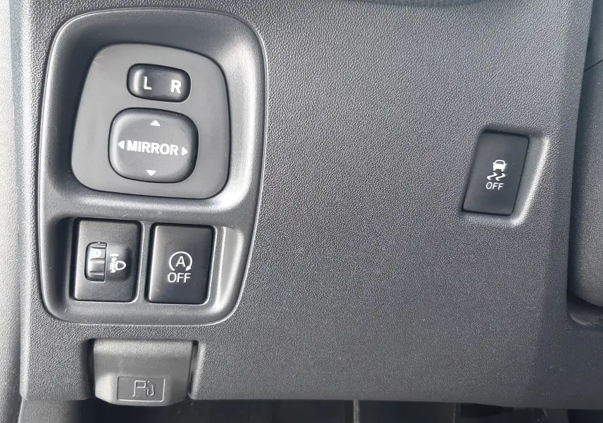 Gros plan sur les commandes noires côté gauche du tableau de bord d'une Citroën C1 gris foncé, version Shine 2019.