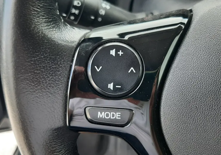 Gros plan sur les commandes audio noires intégrées au volant en cuir de la Citroën C1 gris foncé 2019.