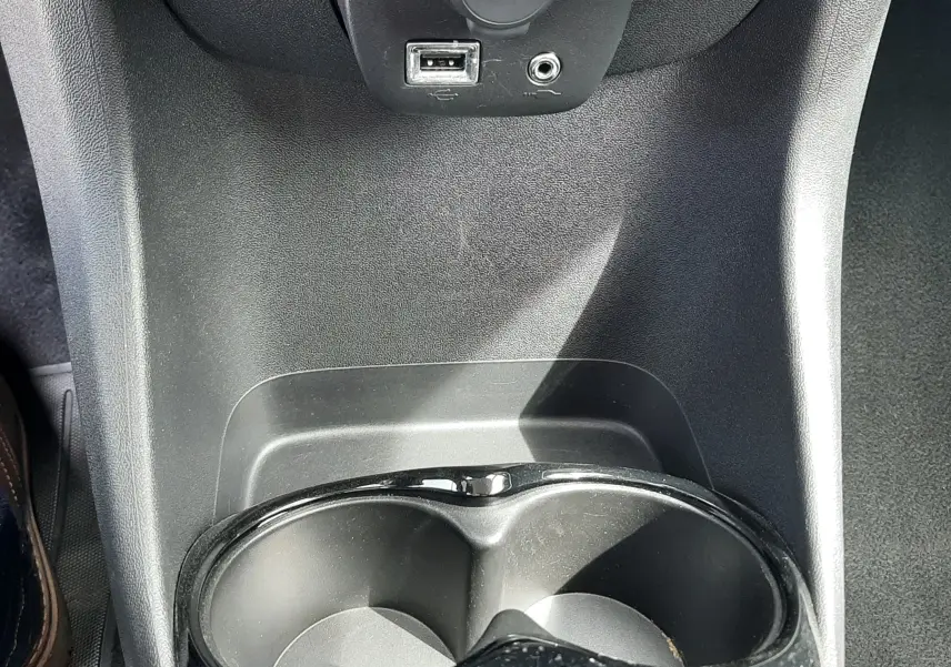 Prise 12V avec port USB et prise jack au-dessus des porte-gobelets dans l’habitacle noir de la Citroën C1 2019.