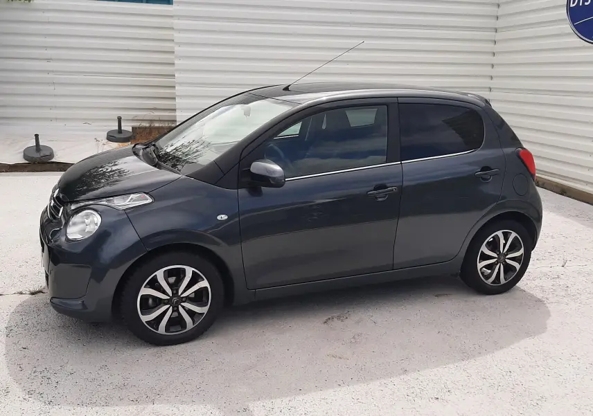 Citroën C1 gris foncé vue de profil côté gauche, compacte 5 portes avec jantes alliage bicolores.