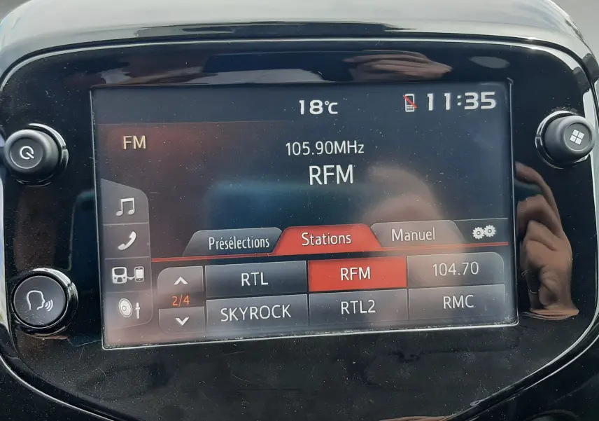 Écran tactile central de la Citroën C1 gris foncé, vue de face, affichant la radio FM sur RFM à 105,90 MHz.
