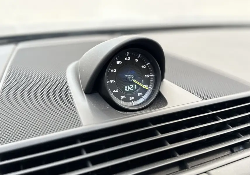 Gros plan sur l'horloge analogique noire intégrée au tableau de bord de la Porsche Panamera 4 E-Hybrid Sport Turismo.