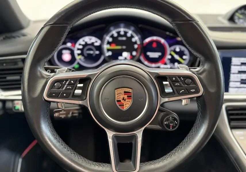Volant cuir noir multifonctions de Porsche Panamera 4 E-Hybrid Sport Turismo, vue frontale rapprochée sur le tableau de bord.