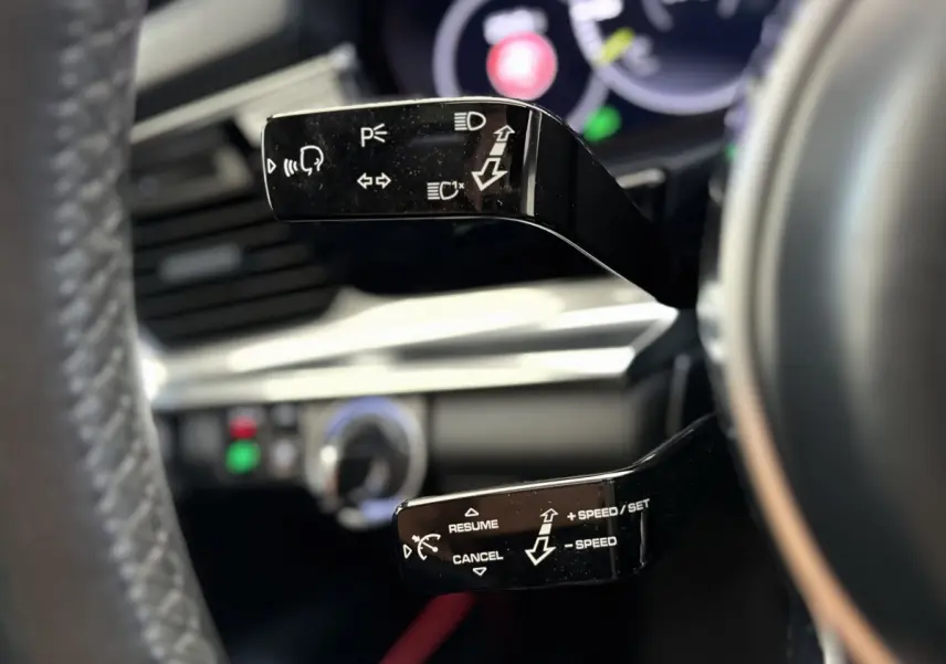 Gros plan sur les commandes au volant noir de la Porsche Panamera 4 E-Hybrid Sport Turismo 2018, intérieur moderne.
