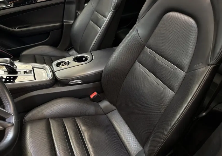 Gros plan sur les sièges avant en cuir noir perforé et la console centrale de la Porsche Panamera 4 E-Hybrid Sport Turismo 2018.