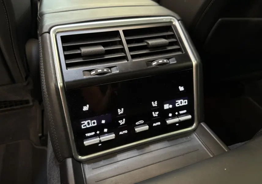 Détail de la console arrière noire de la Porsche Panamera 4 E-Hybrid avec commandes tactiles de climatisation et aérateurs.
