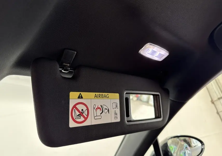 Détail du pare-soleil côté conducteur avec miroir intégré et éclairage intérieur allumé dans une Porsche Panamera 4 E-Hybrid noire.
