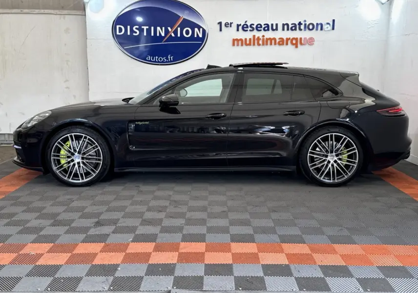 Vue de profil côté gauche d'une Porsche Panamera 4 E-Hybrid Sport Turismo noire avec jantes alliage et étriers verts.