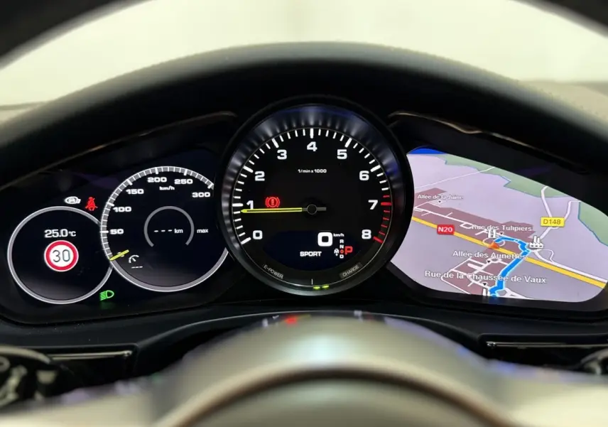 Vue rapprochée du tableau de bord numérique de la Porsche Panamera 4 E-Hybrid Sport Turismo avec affichage de la navigation et compte-tours.
